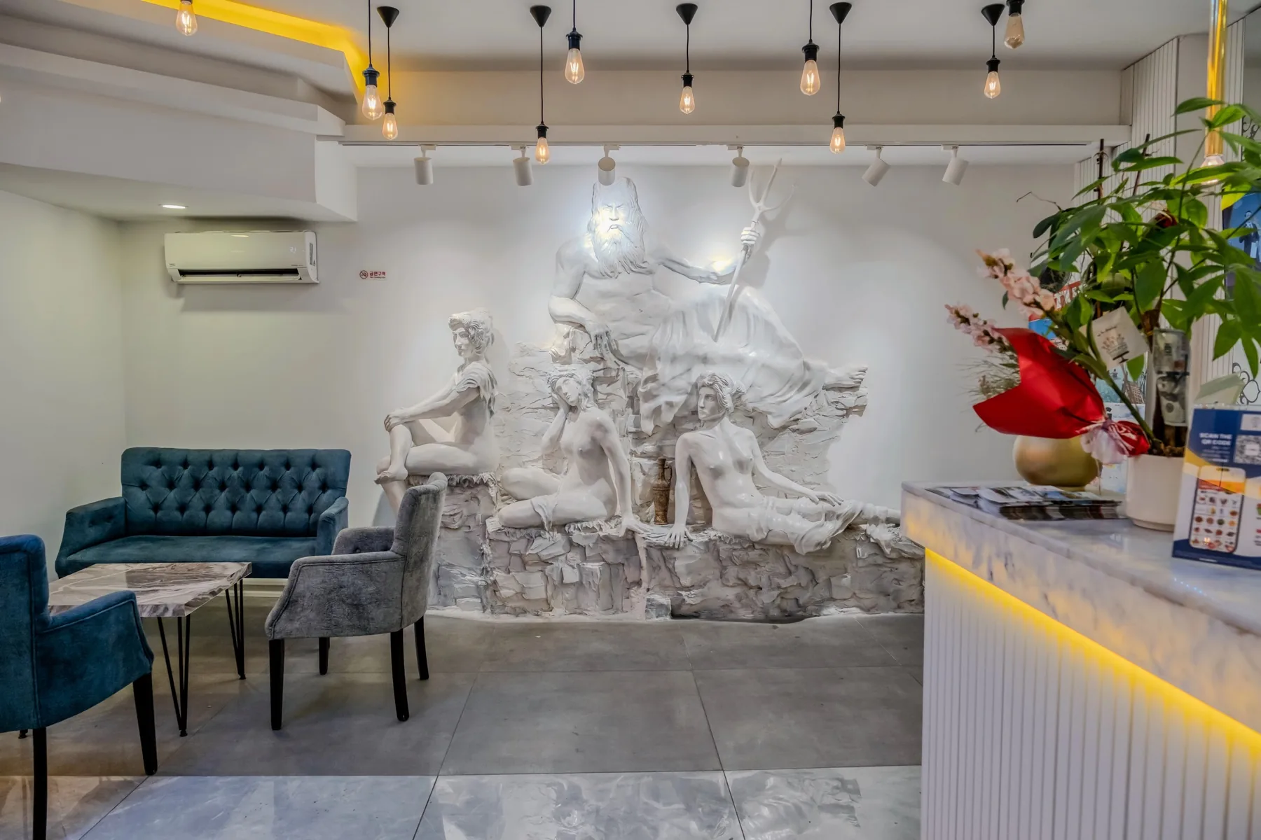 Mİ Hotel Boutique — Resepsiyon yanındaki oturma alanı ve duvar kabartması
